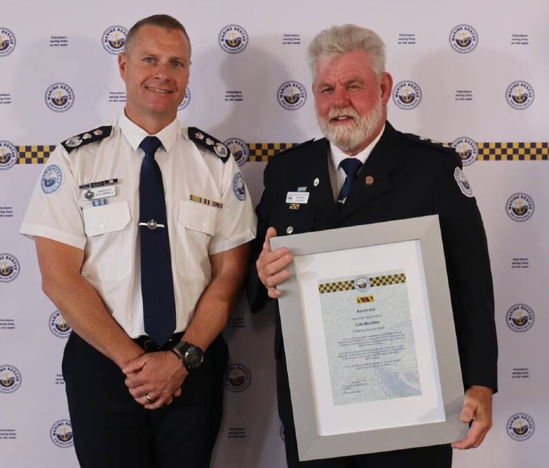 Marine Rescue NSW Commissioner Alex Barrell (left) presents Jervis Bay unit commander Kevin Hill with his life membership. Picture supplied.