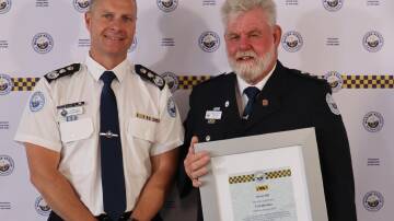 Marine Rescue NSW Commissioner Alex Barrell (left) presents Jervis Bay unit commander Kevin Hill with his life membership. Picture supplied.