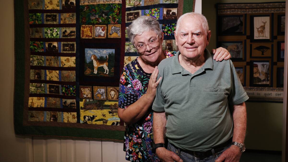 Jenny Elliott with her father Barry Whitehead at his Barrack Heights home. The quilt in the far right was made by Barry's wife Sue Whitehead. Picture by Sylvia Liber