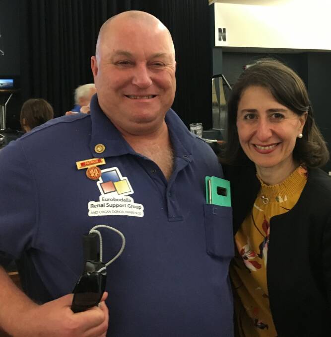 BRAD AND GLAD: Eurobodalla Shire health campaigner Brad Rossiter with NSW Premier Gladys Berejiklian in Batemans Bay in March. "She said I had great legs," the double amputee said. Mr Rossiter wants a better highway.