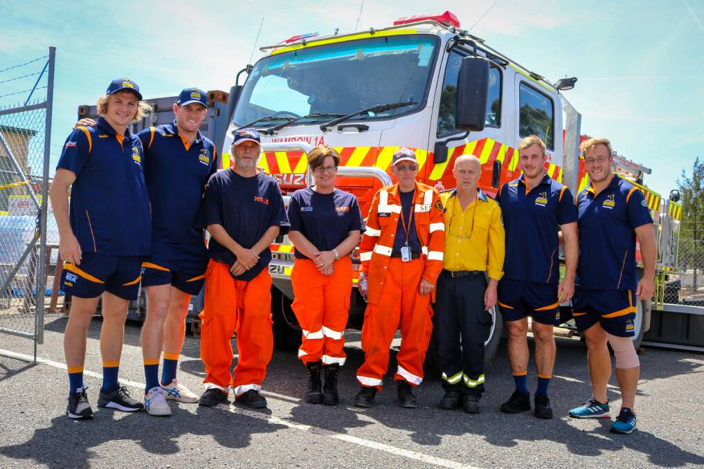 Brumbies' Joe Powell, Tom Cusack, Will Miller and Harry Lloyd with the NSW Rural Fire Service. Photo: Brumbies Media