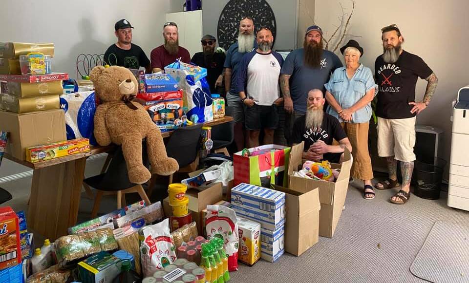 Members of the Bearded Villains drop in with a huge haul of donated toys, gifts and food for SEWACS and service manager Caroline Long.