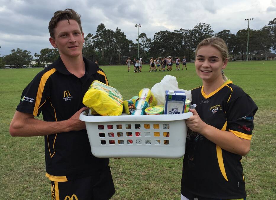 Bomaderry Tigers' Jack Boxsell and Lily McDonald with the collected food which all will be donated.