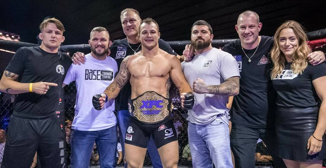 Michael Moss (centre) and his team after claiming his XFC belt against Alex Hong. Photo: SUPPLIED