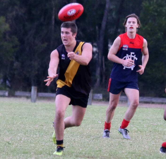 SELLING CANDY TO THE DEFENDERS: Bomaderry Tigers midfielder Tyson Sue gets a hand ball away against the Nowra/Albatross Vikings on Saturday at Artie Smith Oval. Photo: CATHY RUSSELL