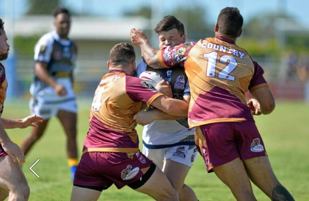 Country's Jesse Dee (12) makes a tackle against City. Photo: QRL