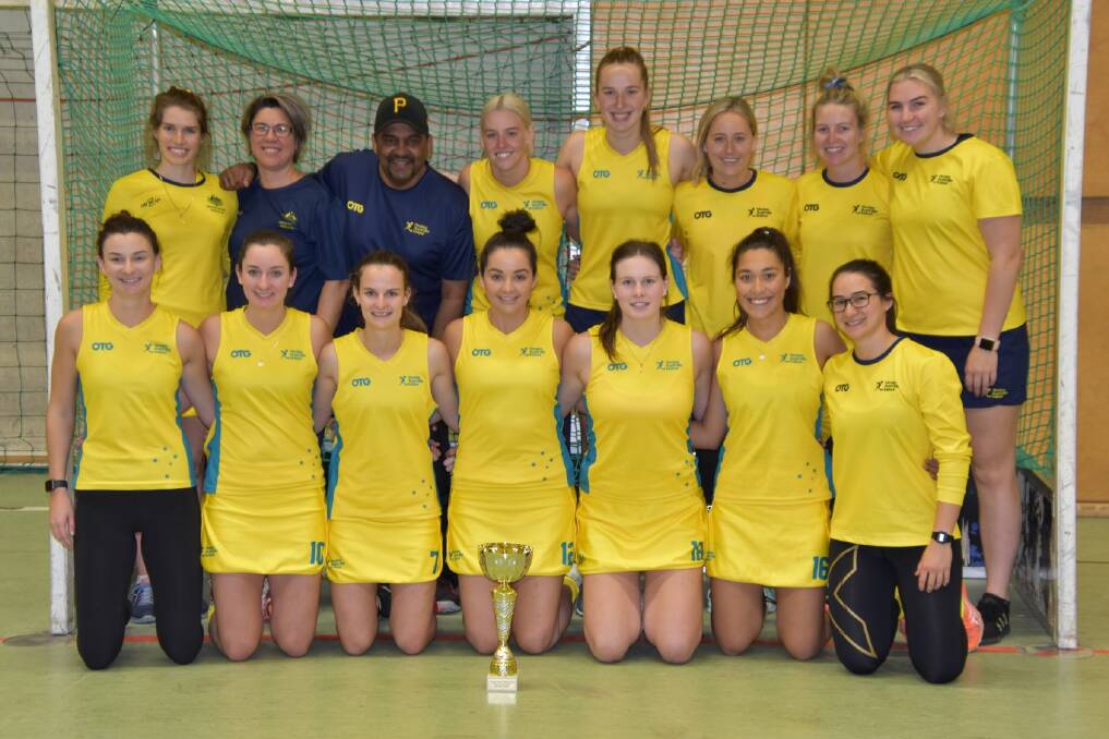 Kyah Gray (back left) and his Australian open women's indoor hockey team with their trophy. Photo: Kenzi Link Curley