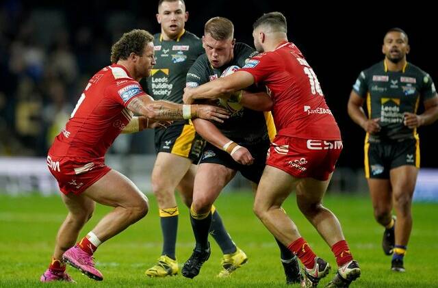 Leeds Rhinos' Tom Holroyd is tackled by Hull Kingston Rovers' Korbin Sims and Matthew Storton. Photo: PA
