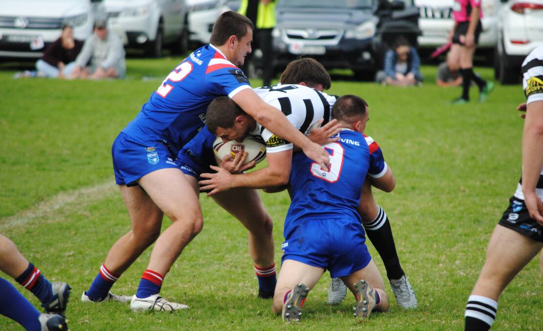 Magpies' Blake Phillips is wrapped up by three Lions' defenders. Photo: Damian McGill