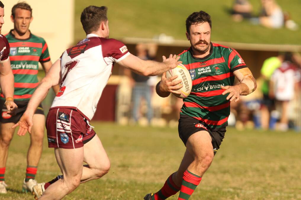 Jamberoo's Daniel Burke tries to avoid being tackled by Albion Park-Oak Flats' Sam Clune. Photo: David Hall