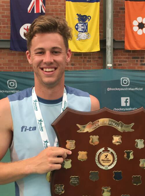 NATIONAL SUCCESS: Shoalhaven's Alex Mackay with the shield his NSW open men’s indoor team won at the Australian Indoor Championships in Unanderra. Photo: JUANITA MACKAY