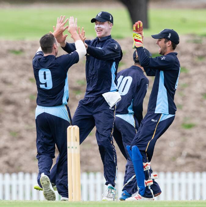 ACT/NSW Country's Kaleb Phillips (centre) celebrates a wicket with his teammates. Photo: CRICKET AUSTRALIA