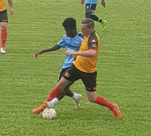 Matt White (yellow) in action for the Mariya against the Africa Nations Football Association.