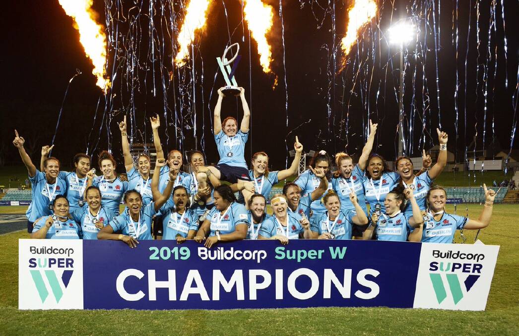 Ash Hewson holds up the Super W trophy, while being held up by her Waratahs team mates. Photo: RUGBY NSW