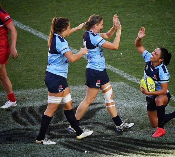 Ashleigh Hewson (middle) celebrates a try with her Waratahs' team mates.
