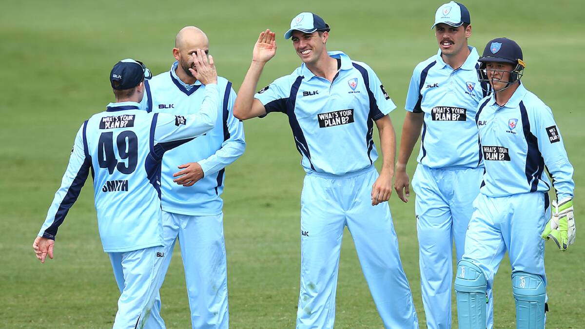Matthew Gilkes (right) celebrates a wicket on Monday with his Blues teammates. Photo: Cricket NSW
