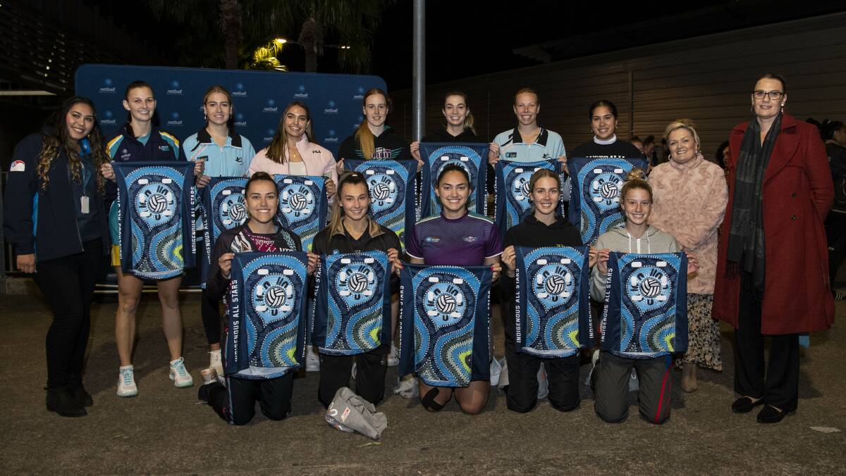 Tegan Holland, Emily Dunn and their Netball NSW Indigenous All-Stars team with dress design artist Maree Bisby (back row, second from right). Photo: May Bailey/Clusterpix Photography