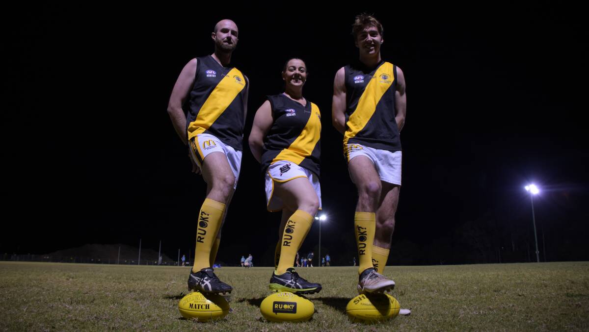 Bomaderry Tigers' Brent Tyrrell, Simone Gibbs and Charlie Rodden in their special R U OK? socks and with the R U OK? footy. Photo: COURTNEY WARD