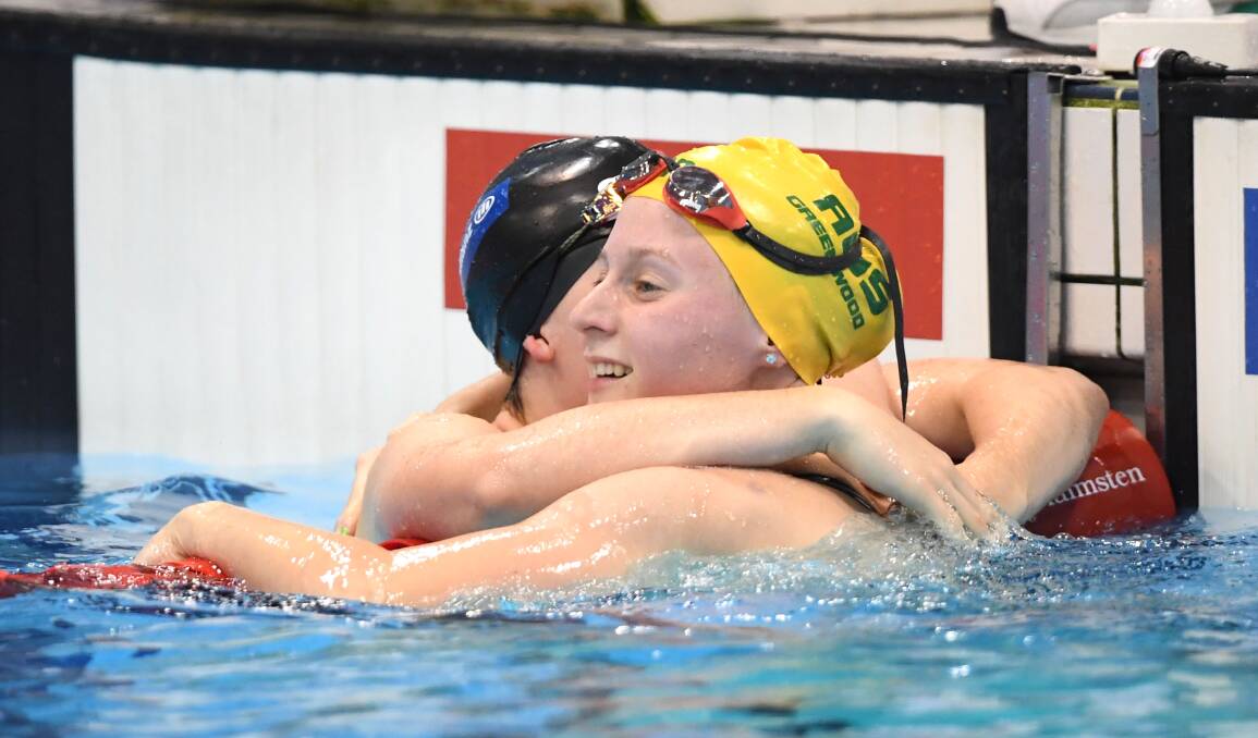 Sussex Inlet's Jasmine Greenwood celebrates with a rival during a recent swim meet. Photo: SWIMMING AUSTRALIA
