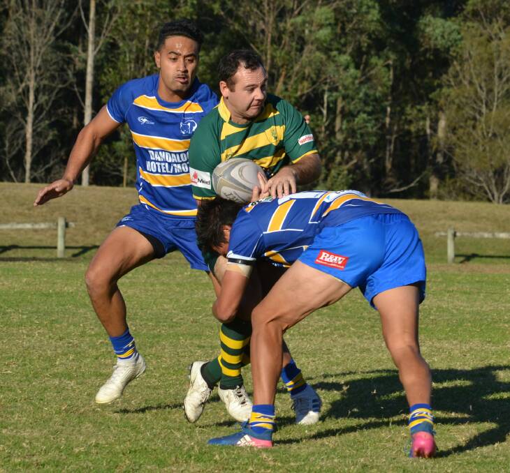 BIG HIT: Shoals skipper Steven Brandon is tackled by two Avondale defenders. Photo: DAMIAN McGILL
