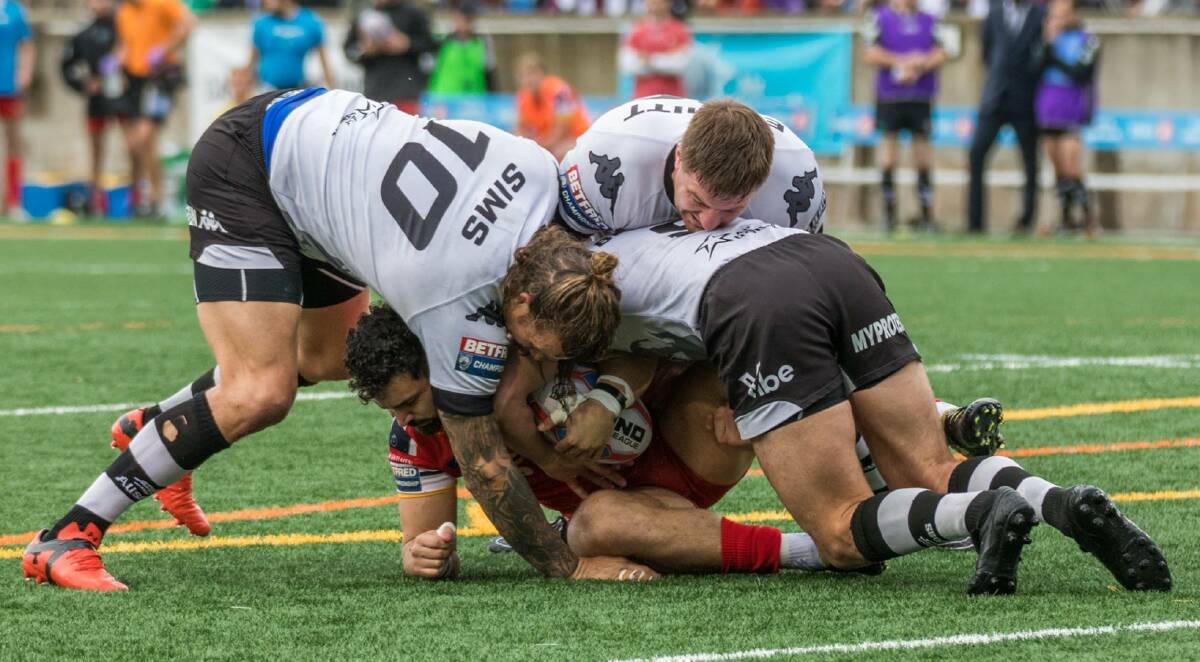 Toronto's Ashton Sims (left) makes a tackle during the match against London. Photo: Mathew Tsang (River Spiral Photography)