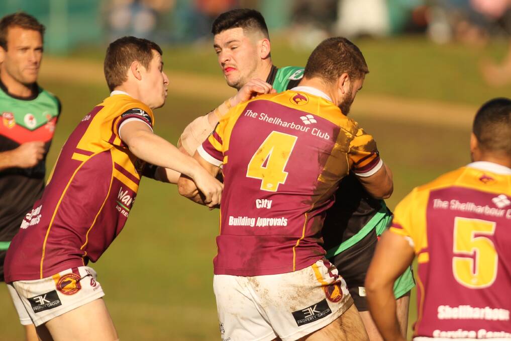 Jamberoo's Kyle Stone is tackled by two Shellharbour defenders. Photo: David Hall
