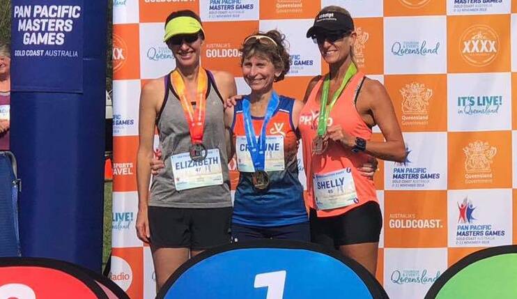 ALL SMILES: Elizabeth Cox, Cristine Suffolk and Shelly Ostrouhoff on the podium of the  4km cross country race at the Pan Pacific Masters Games.