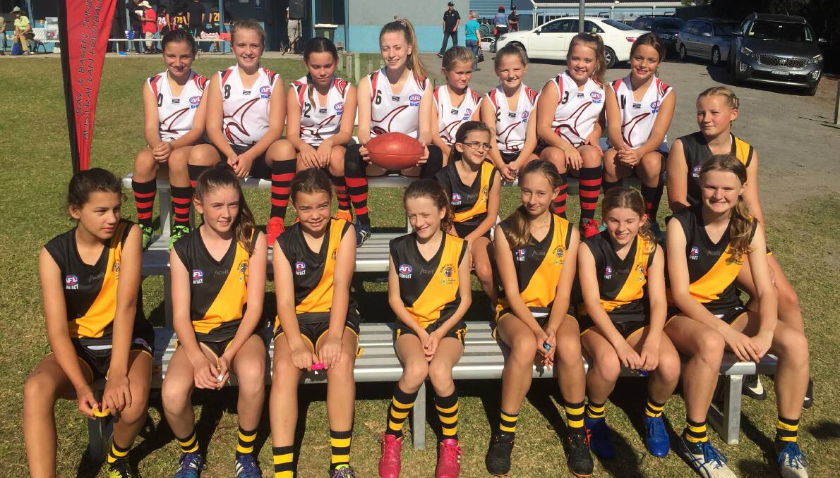 All smiles: The Bay and Basin Bombers under 13 girls team with the Bomaderry under 13 girls side before both took to the field on Sunday.