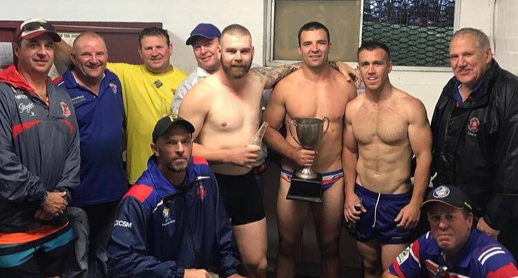Scott Stewart (front left), Michael Cronin (back right), with players Tim Moore, Nathan Ford and Rixon Russell, and other Lions staff and players after the 2020 title. Photo: Supplied