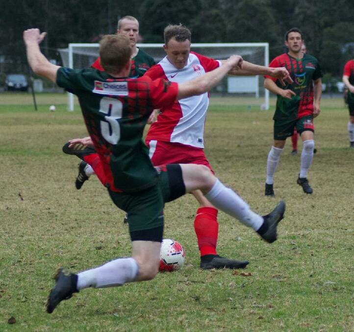 Basin's Tim White looks to get a kick away despite pressure from an Illaroo defender. Photo: Louise Marr