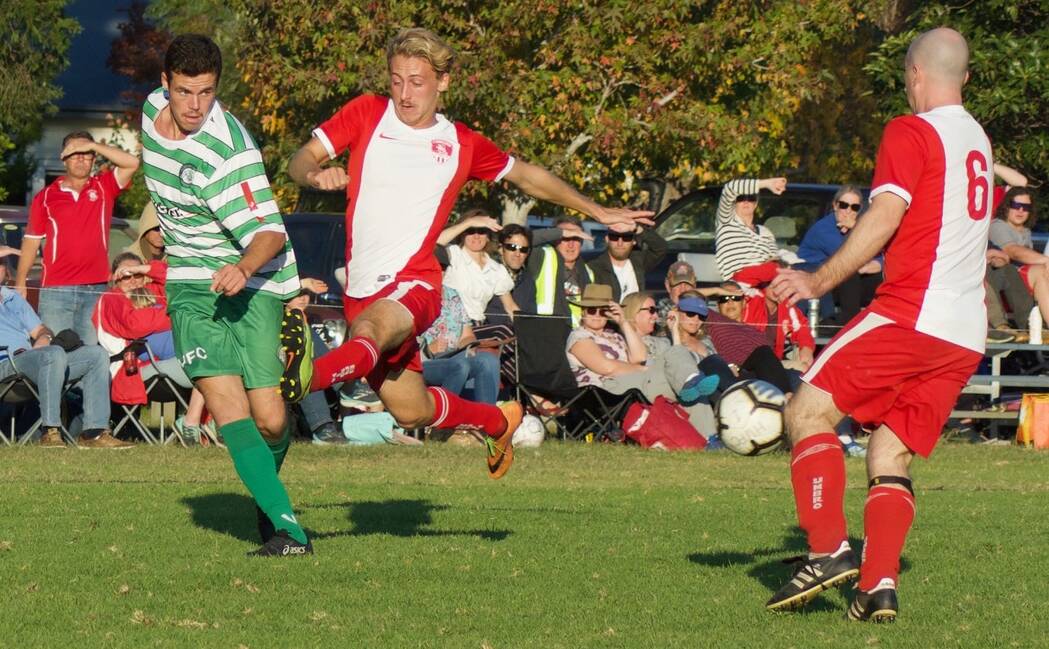 TIGHT CONTEST: Huskisson-Vincentia's Lewis Archibald gets a pass away despite defensive pressure from St Georges Basin's Wade Garin on Saturday. Photo: LOUISE MARR