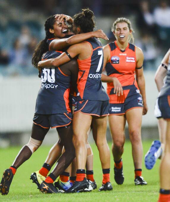 Maddy Collier (back) and her GWS Giants celebrate a goal against Geelong. Photo: Rohan Thomson