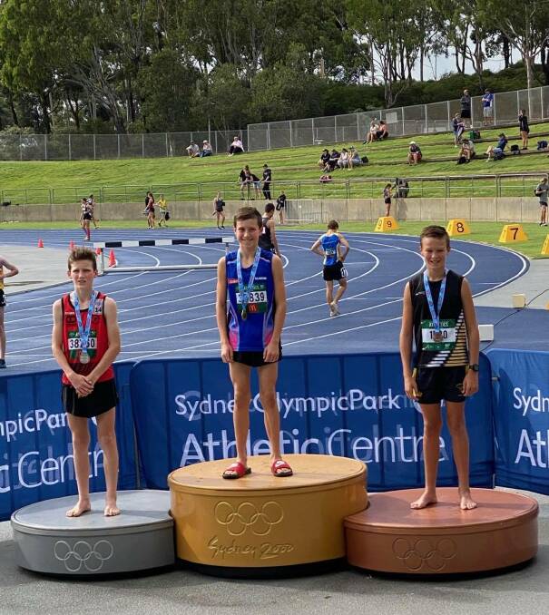On the podium: Nowra Athletics Club's Cooper Barrett, right, after being presented with his steeplechase bronze medal.
