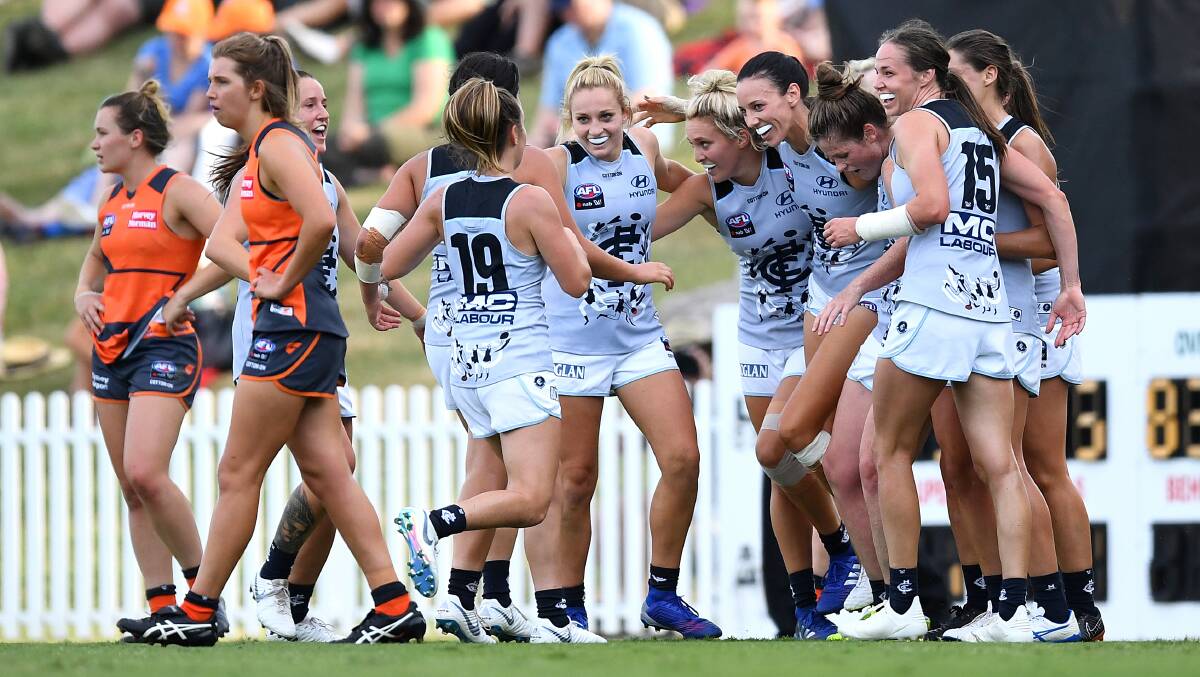 Maddy Collier (left) and her Giants regroup after conceding a goal to Carlton. Photo: Dylan Coker