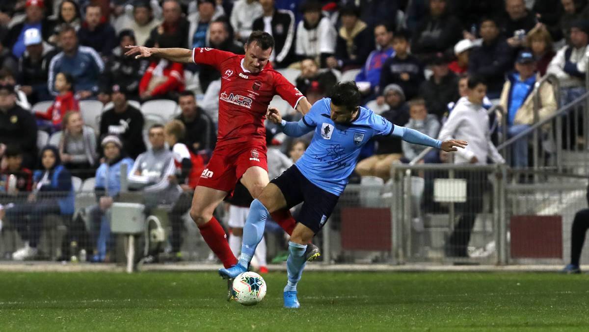 Wollongong Wolves' Chris Price tries to win possession against Sydney FC's Adam Le Fondre. Photo: SYLVIA LIBER