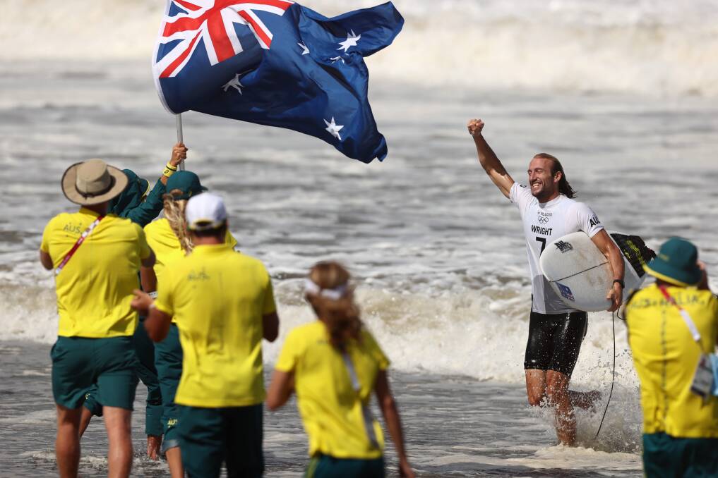 Culburra Beach's Owen Wright exits the water to celebrate with his Australian teammates after winning the bronze medal. Photo: Ryan Pierse