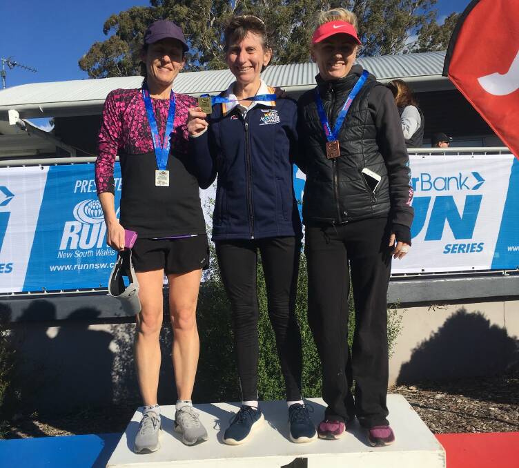 Gold medal: Nowra's Cristine Suffolk (centre) won the women’s 45-49 years 7500m race.