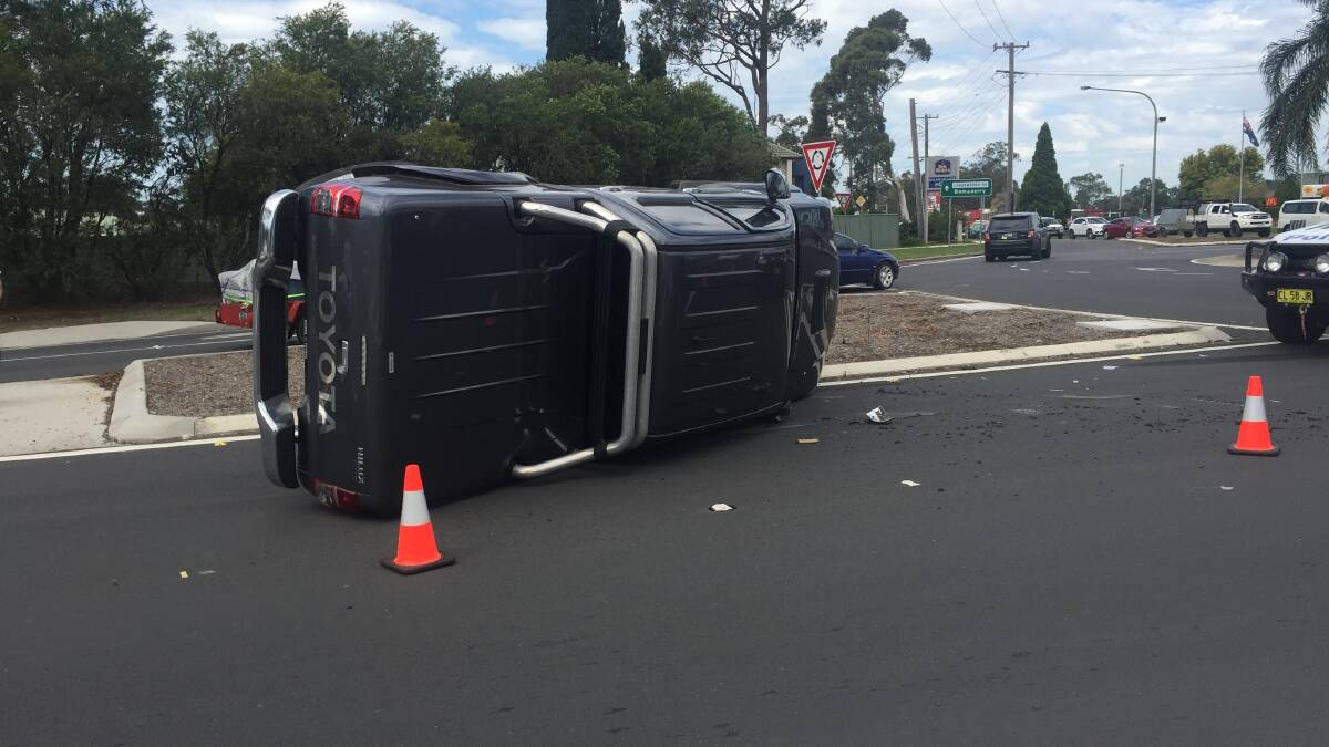 HOLD-UP: The ute that rolled over at the Moss Vale Road-Princes Highway roundabout. While this accident is being cleared another collision at the Meroo Road-Princes Highway intersection is adding to delays. Photo: Rebecca Fist
