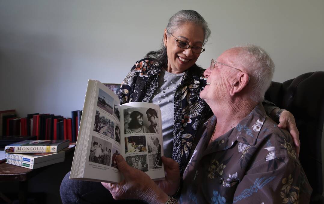 ENDURING LOVE: Kim Dung and Carl Robinson share a laugh over their photo in the book The Bite of the Lotus. Photo: Sylvia Liber
