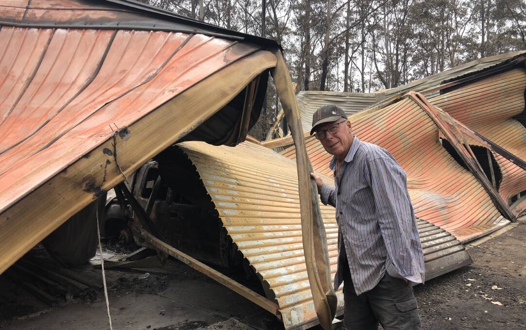 BUCKLED: Chris Atkinson inspects the shed on his Woodburn Road property that fell victim to Saturday's blaze. Photo: John Hanscombe 