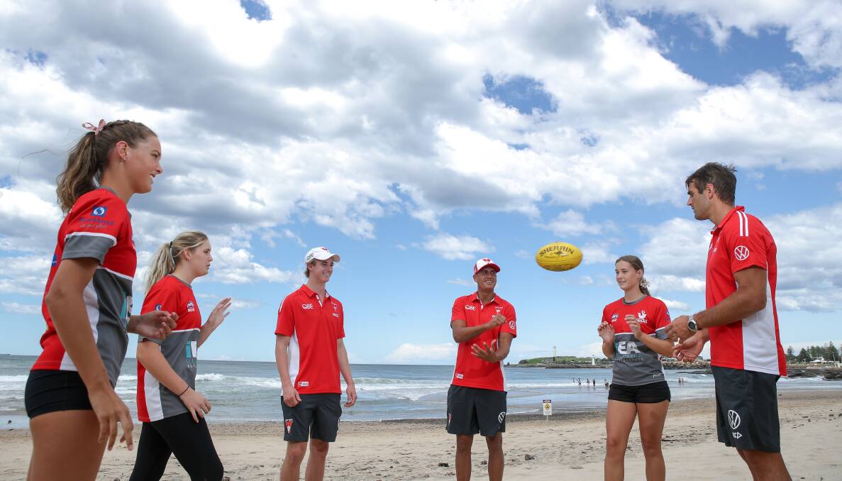 Swans players Harry Reynolds, James Bell and Josh Kennedy meet locals Claire Ridding, Charlotte Ridding and Georgia Ridding at North Wollongong Beach in February. Photo: Adam McLean