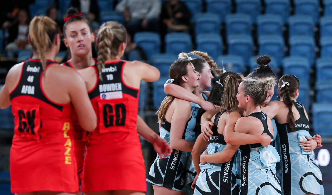 CONTRASTING EMOTIONS: Jessica Bowden (third from left) embraces her South Coast Blaze teammate while Stingrays players celebrate after winning the title on Saturday night. Picture: May Bailey/Clusterpix Photography