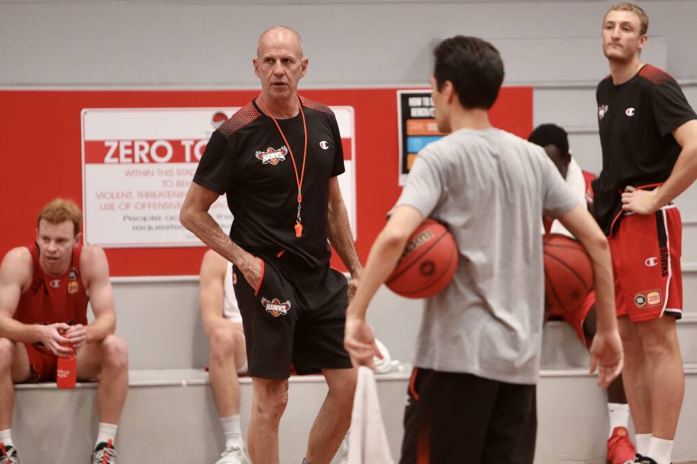 Hawks head coach Brian Goorjian chats with his players after a training session at the Snakepit on Friday. Photo: Adam McLean
