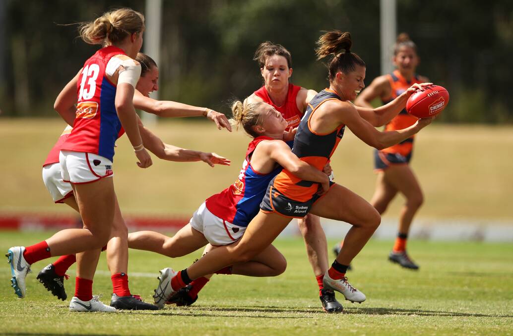 Giants' Taylah Davies aims to burst away from a Demons defender. Photo: Mark Kolbe