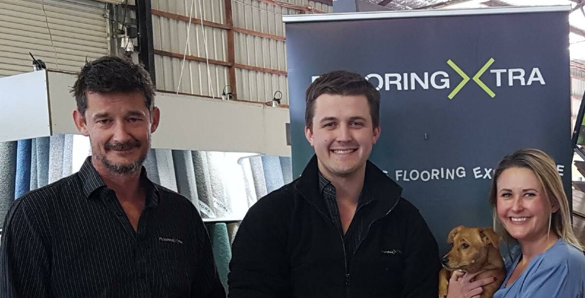 FLOORS AND MORE: Flooring Xtra Nowra owner/manager Arron Brewer, salesperson Jordan Pearson and owner/manager Valerie Baker, with Sprinkles. 