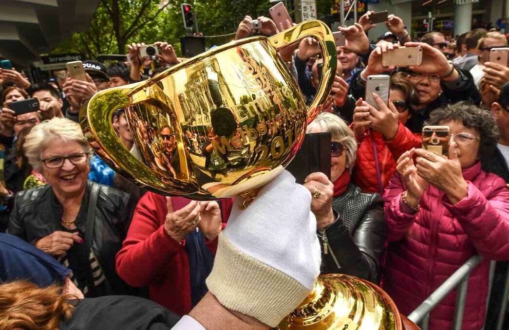 CUP RUNNETH OVER: Many Australians have fallen in love with the Melbourne Cup, which tours the country before being presented to the race winner in November. 