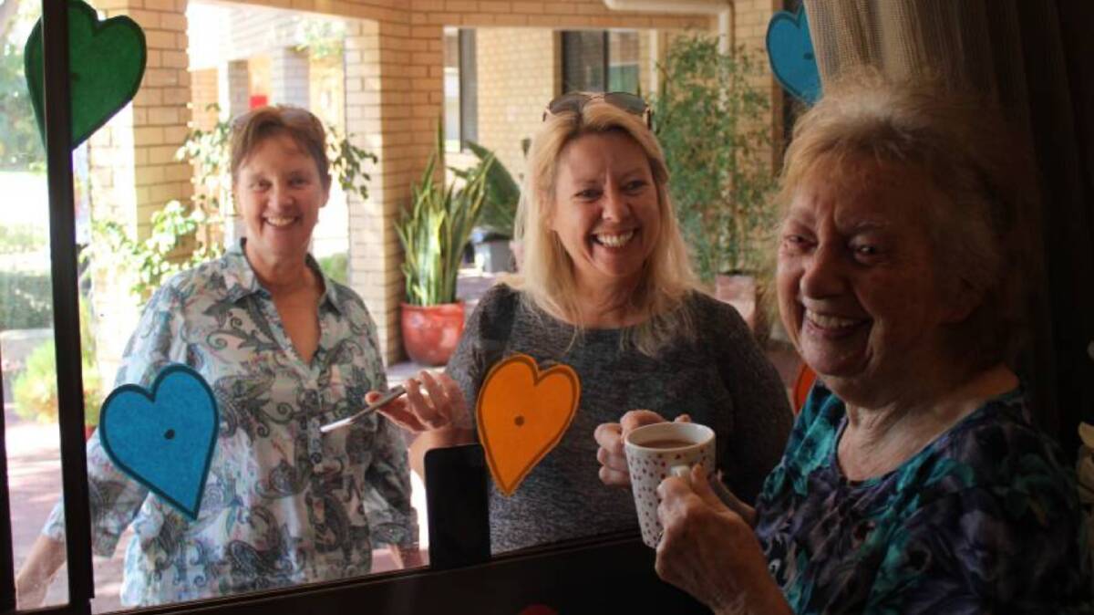 Opal Murray River Care Community resident Alice Singleton meets up with her daughters, Michele and Pauline at the 'Window of Love'.