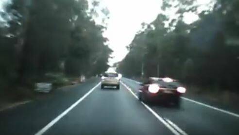 'STUPID': The driver of the black car veers onto the wrong side of the road to overtake Steve Knox, narrowly missing a head on collision with a northbound vehicle.