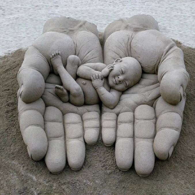 INTERNATIONALLY RECOGNISED: One of Dennis Massoud's most famous creations, hands holding a baby sand sculpture in the Canary Islands. Picture: supplied. 