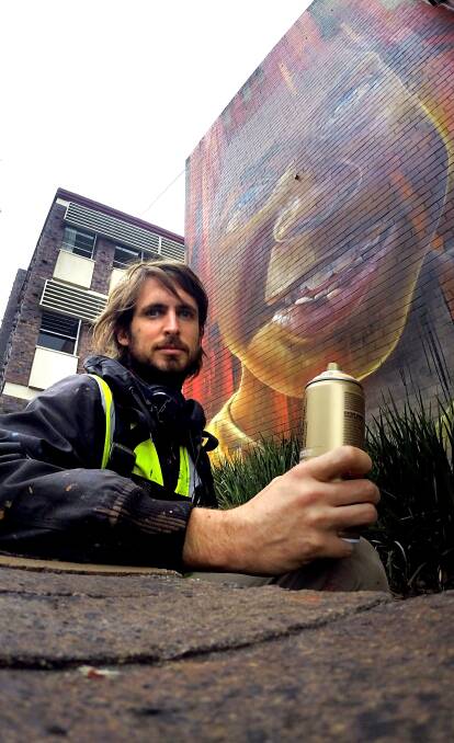 Talent: Matt Adnate finishes the mural on Nowra Library's back wall which took three days, 20 litres of paint and 70 spray cans to finish. Photo: Jessica Long